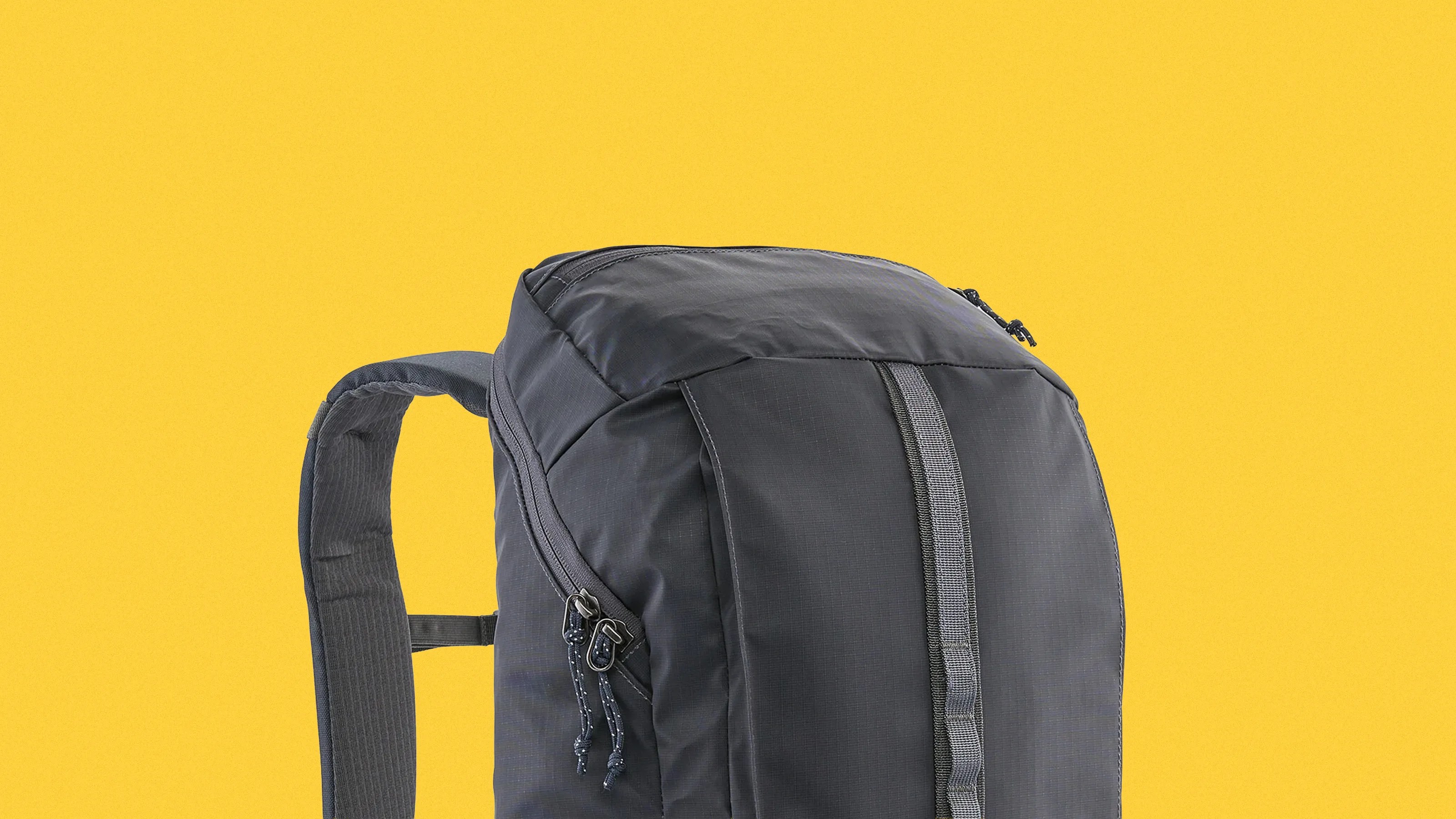Dark gray backpack with padded shoulder strap and vertical webbing detail on a yellow background.