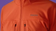 Orange Patagonia fleece jacket with two vertical zippered chest pockets and a high collar.