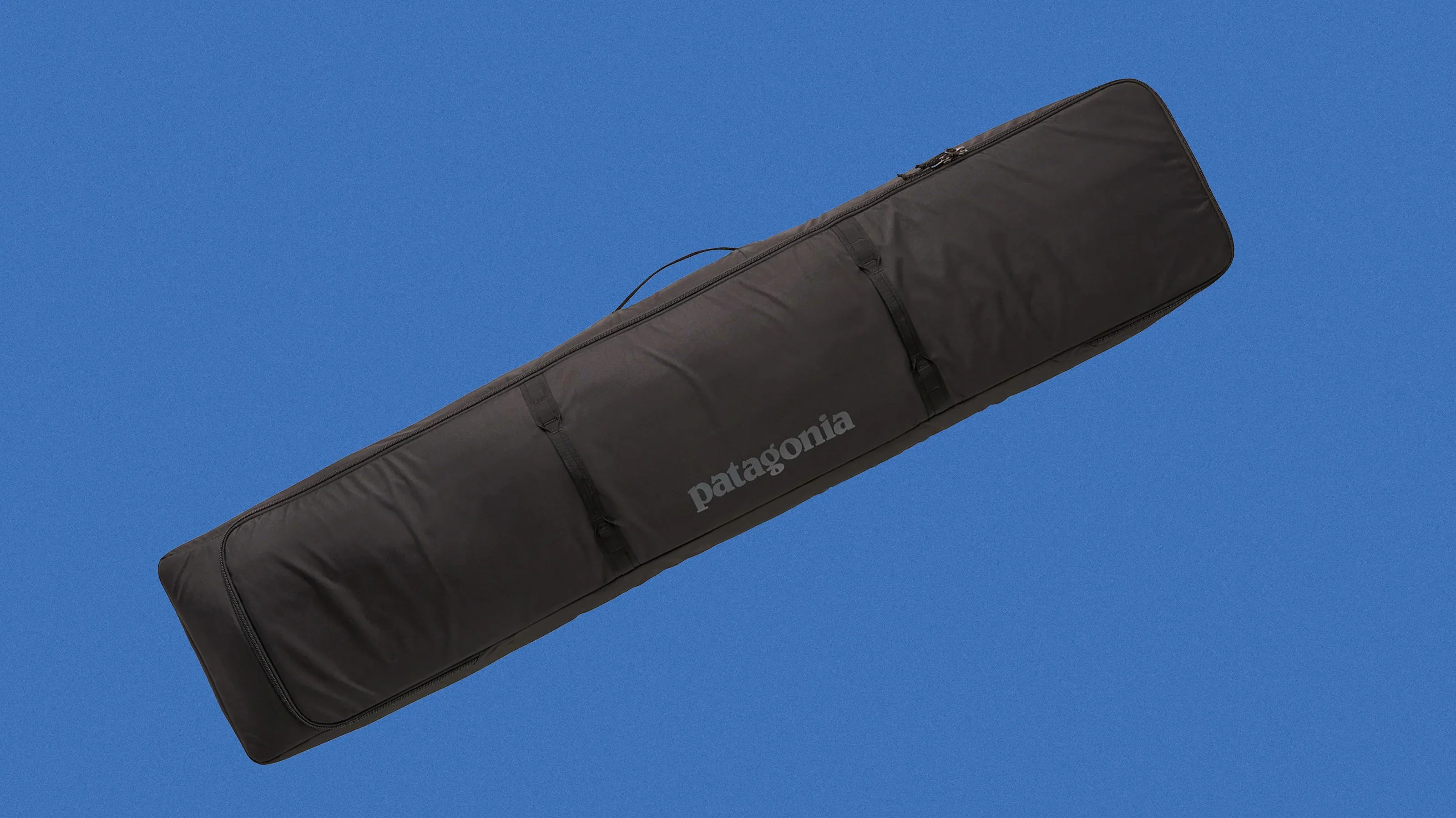 Long black Patagonia padded bag with handles and zipper on a blue background.