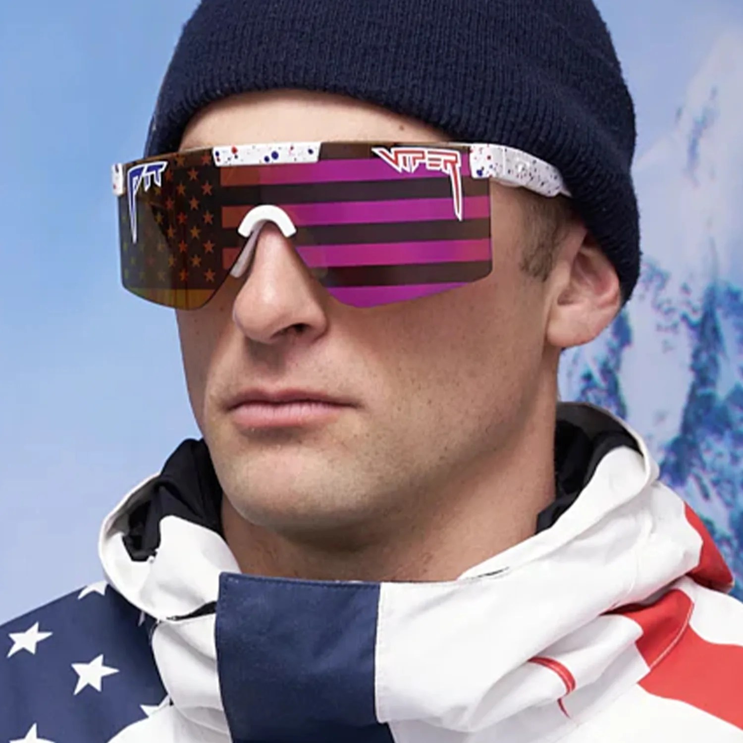 Man wearing large wraparound sunglasses with an American flag design and a navy beanie.