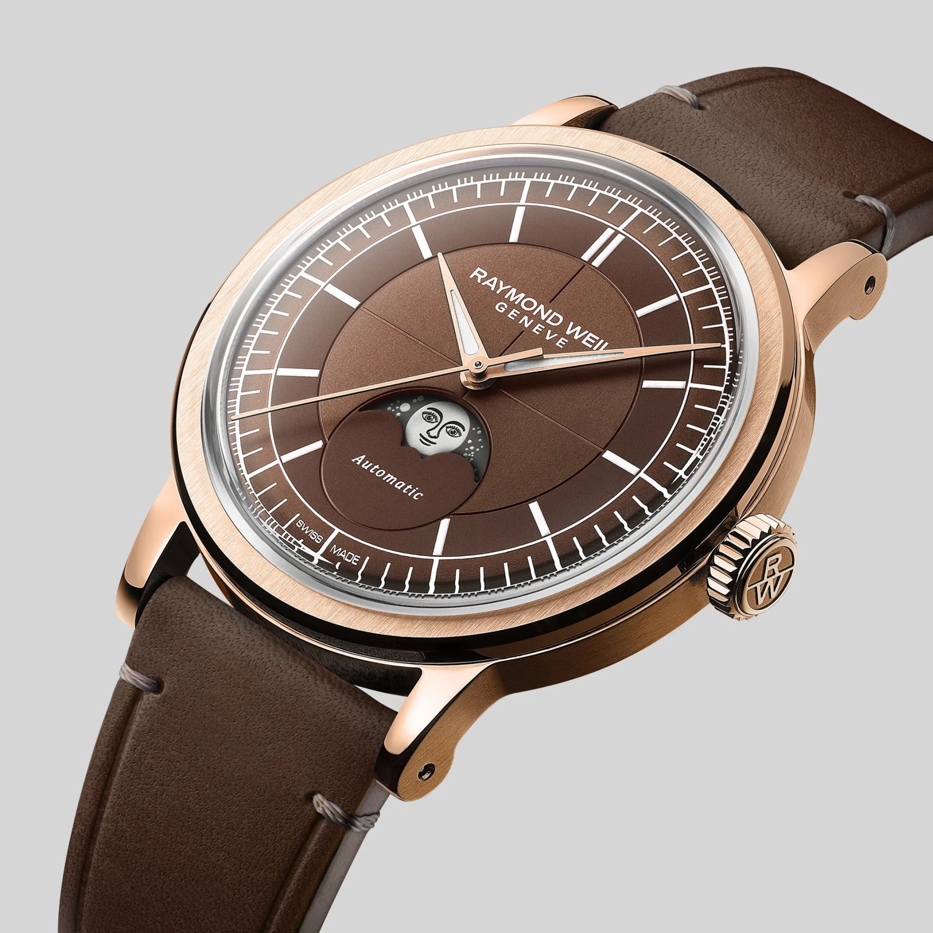 Rose gold Raymond Weil wristwatch with brown dial, moonphase display, and brown leather strap.