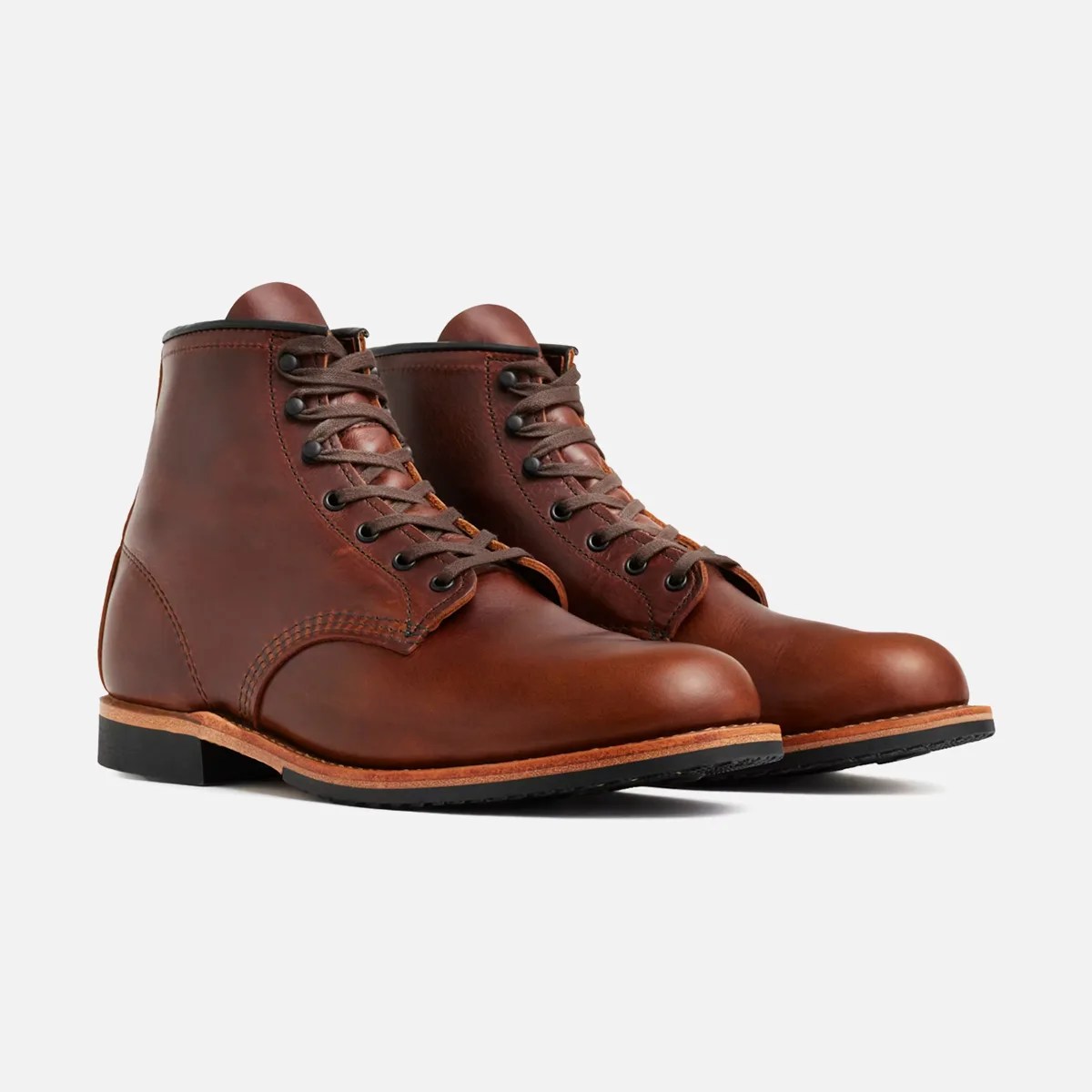 Pair of brown leather lace-up boots with black eyelets and black rubber soles.