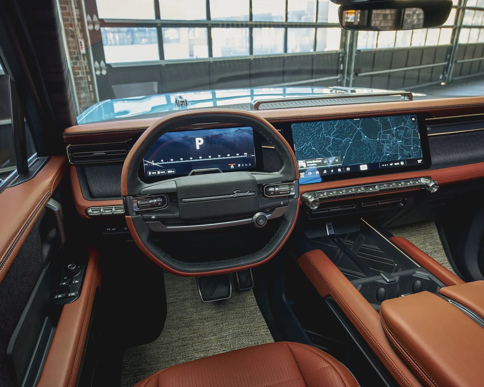 Car interior with brown leather seats and trim, digital dashboard, rectangular steering wheel, and dual widescreen displays.