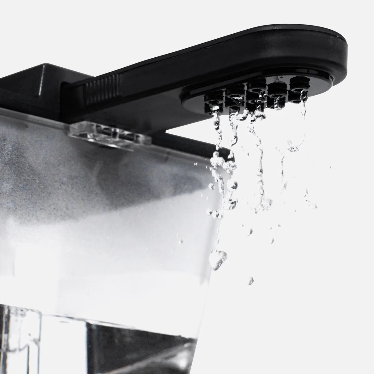 Black plastic water dispenser spout pouring water into a transparent container.