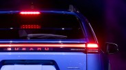 Rear view of a blue Subaru SUV with illuminated brake lights and AWD badge.