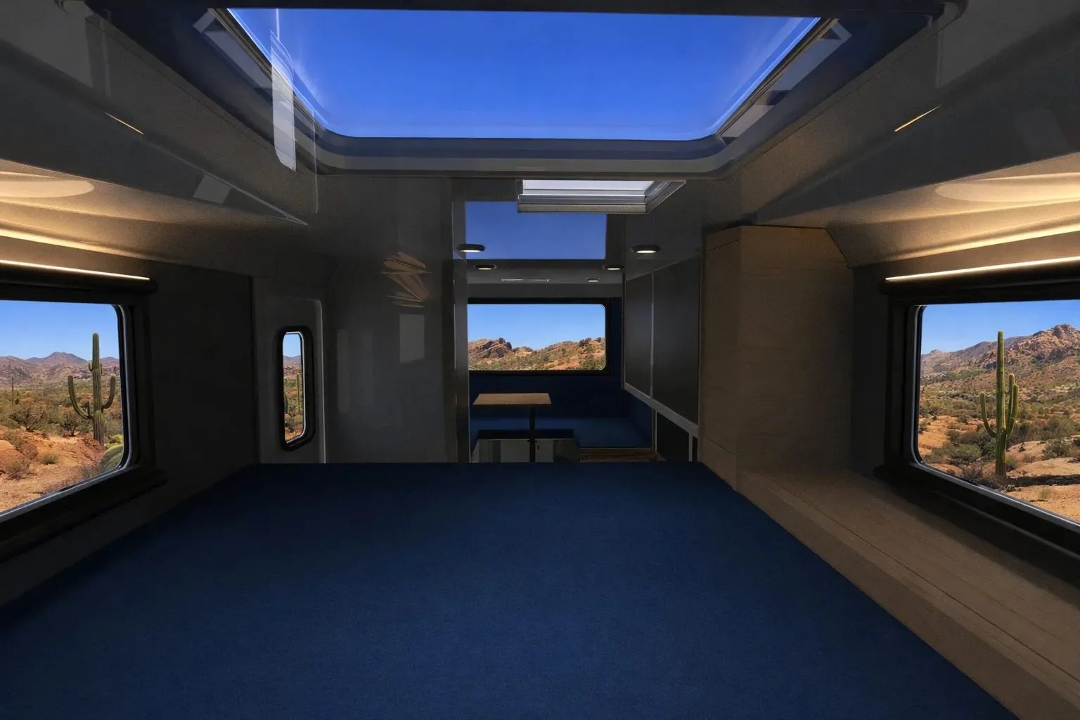 Interior of a modern camper van with blue bedding, large windows showing desert landscape, and a skylight above.