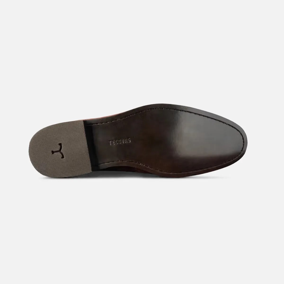 Dark brown leather shoe sole with a textured rubber heel and "TECCVAS" embossed near the arch.
