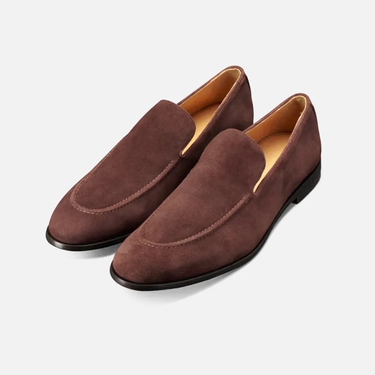 Pair of brown suede slip-on loafers with black soles on a white background.