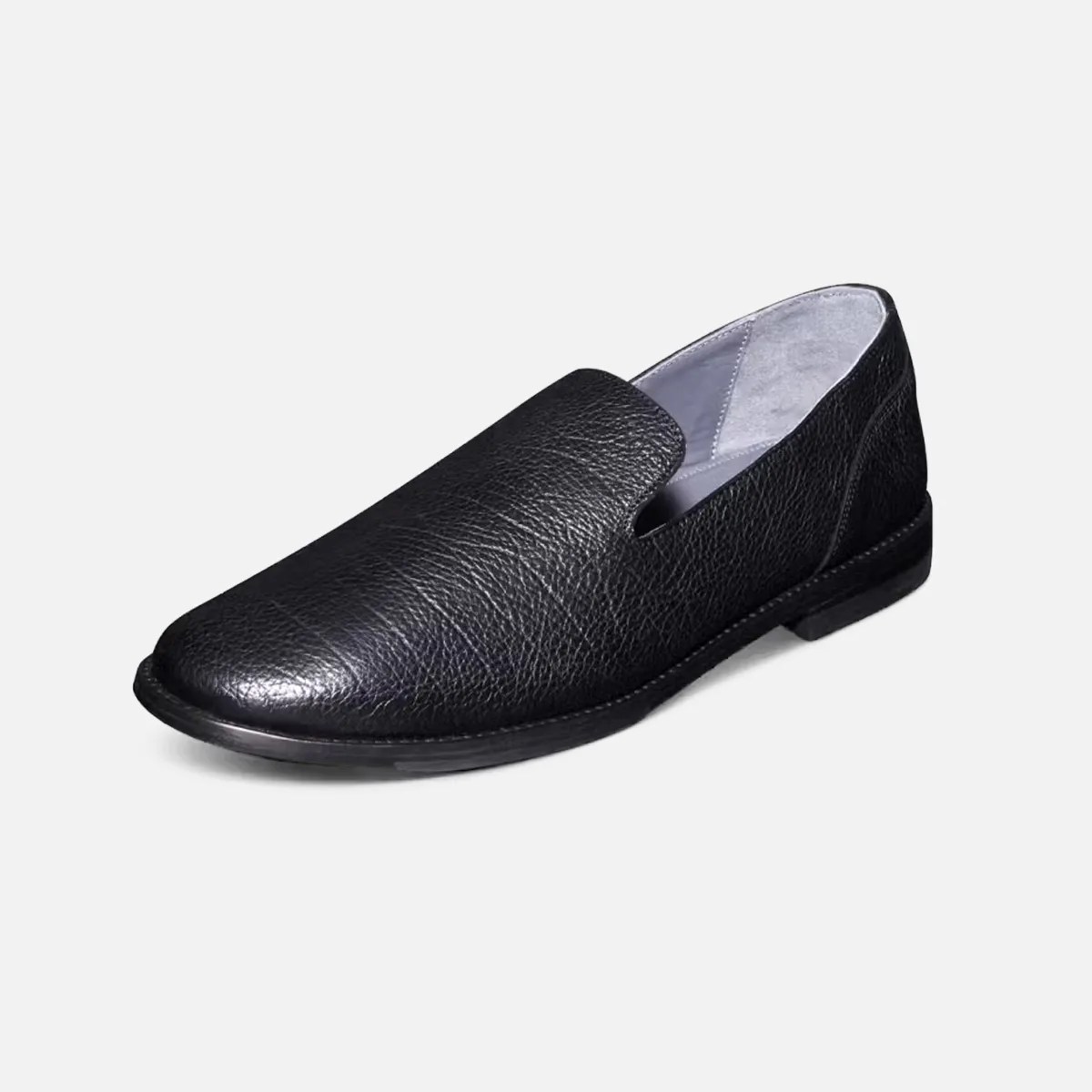 Black textured leather slip-on shoe with a low heel and light gray interior lining.