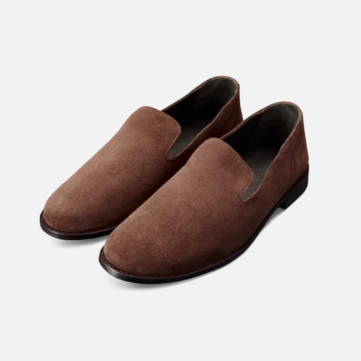 Pair of brown suede slip-on shoes with black soles on a white background.