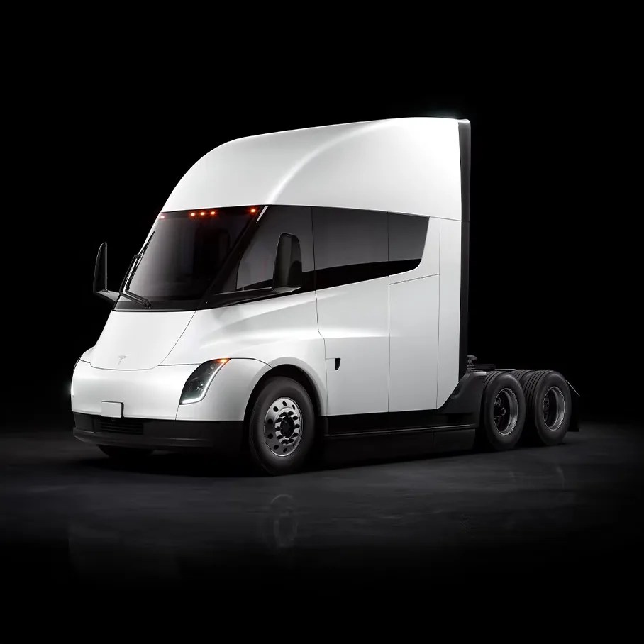 White Tesla electric semi-truck with aerodynamic design and black tinted windows on a dark background.