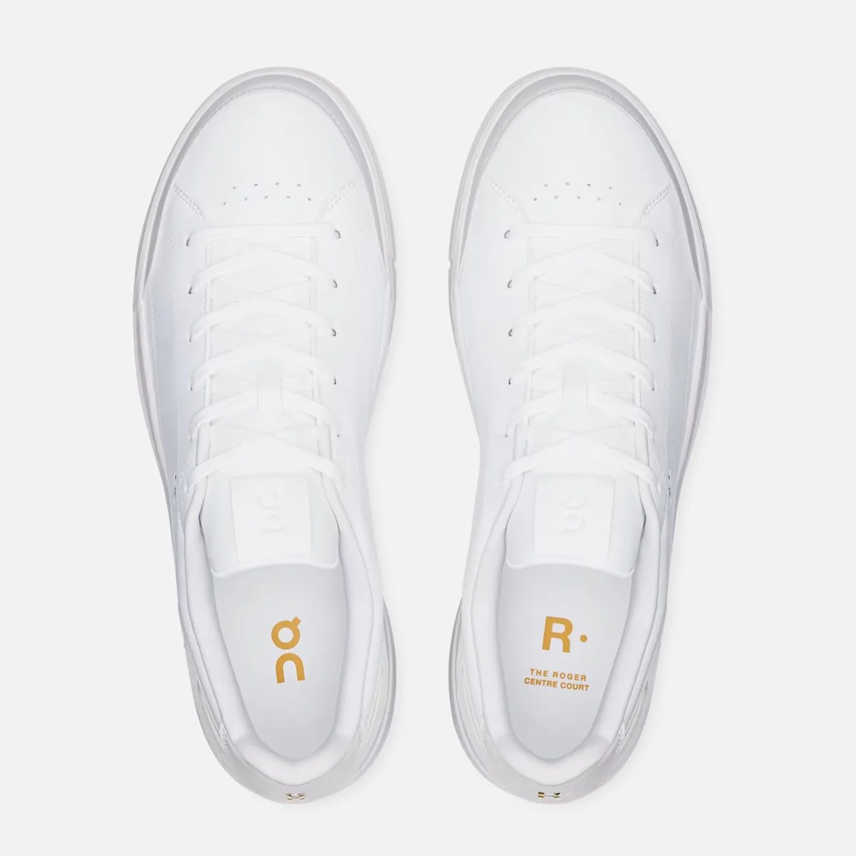 Pair of white leather sneakers with white laces and gold text inside reading "THE ROGER CENTRE COURT.