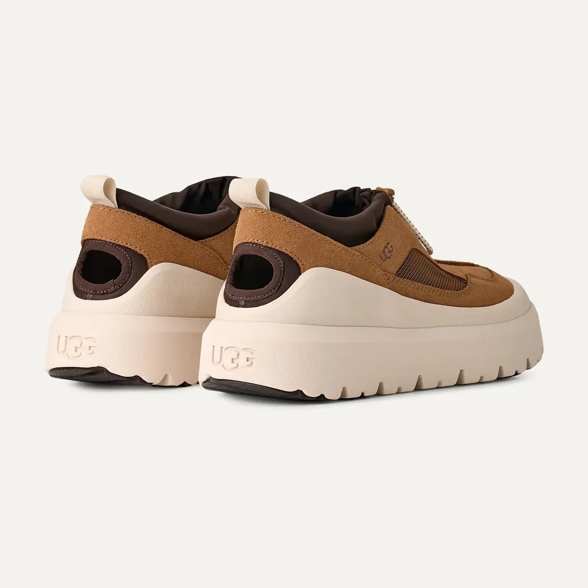 Pair of brown suede UGG sneakers with thick white soles shown from the back and side.
