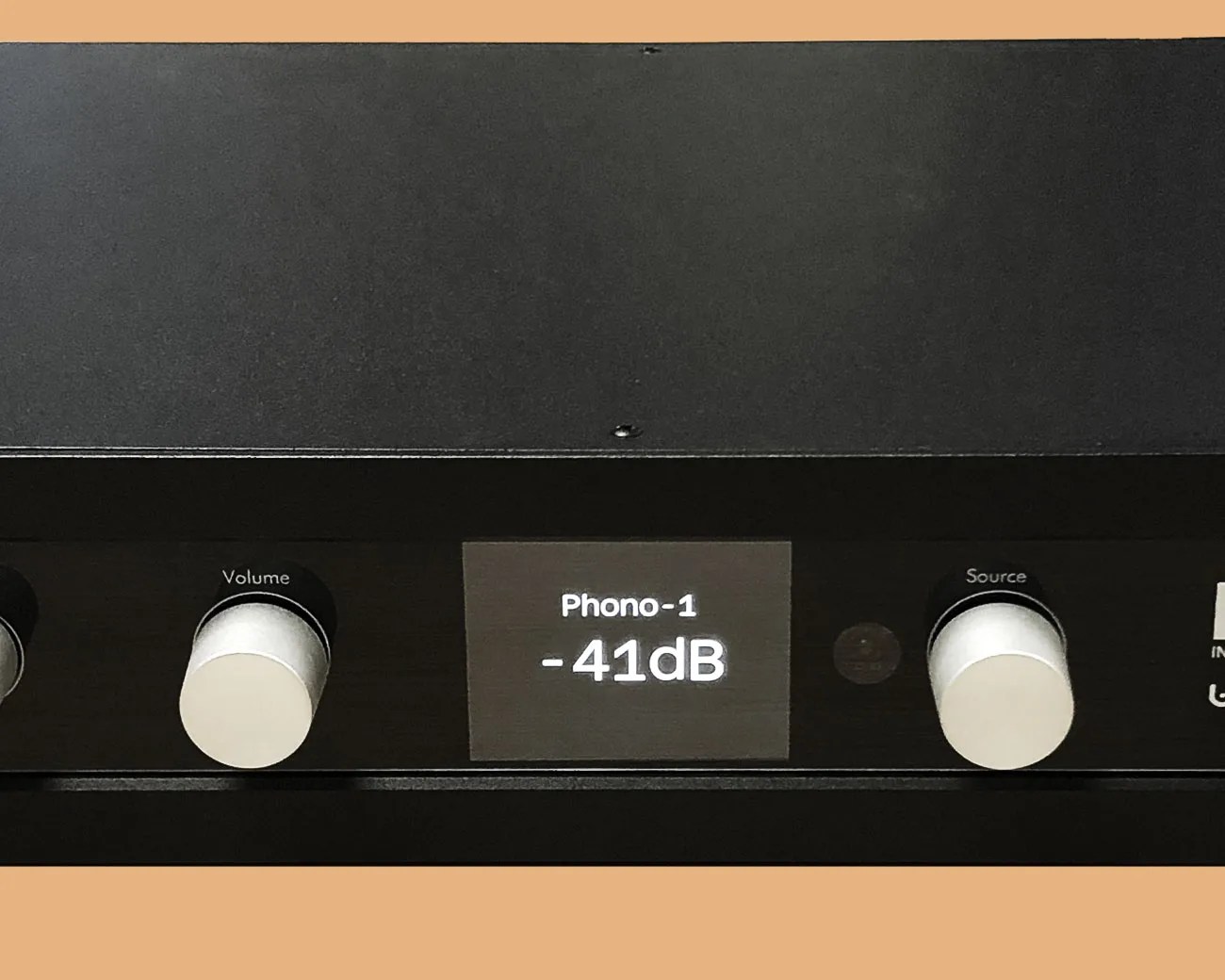 Black audio amplifier front panel with silver volume and source knobs and a digital display showing "Phono-1 -41dB".
