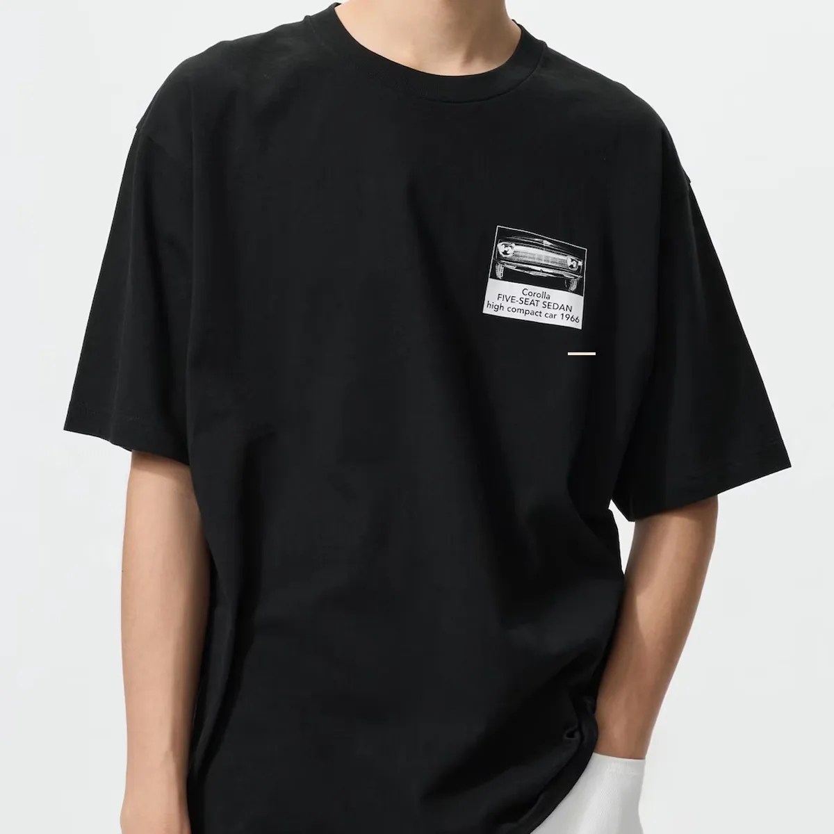Black oversized T-shirt with a small white graphic of a vintage car and text on the chest.