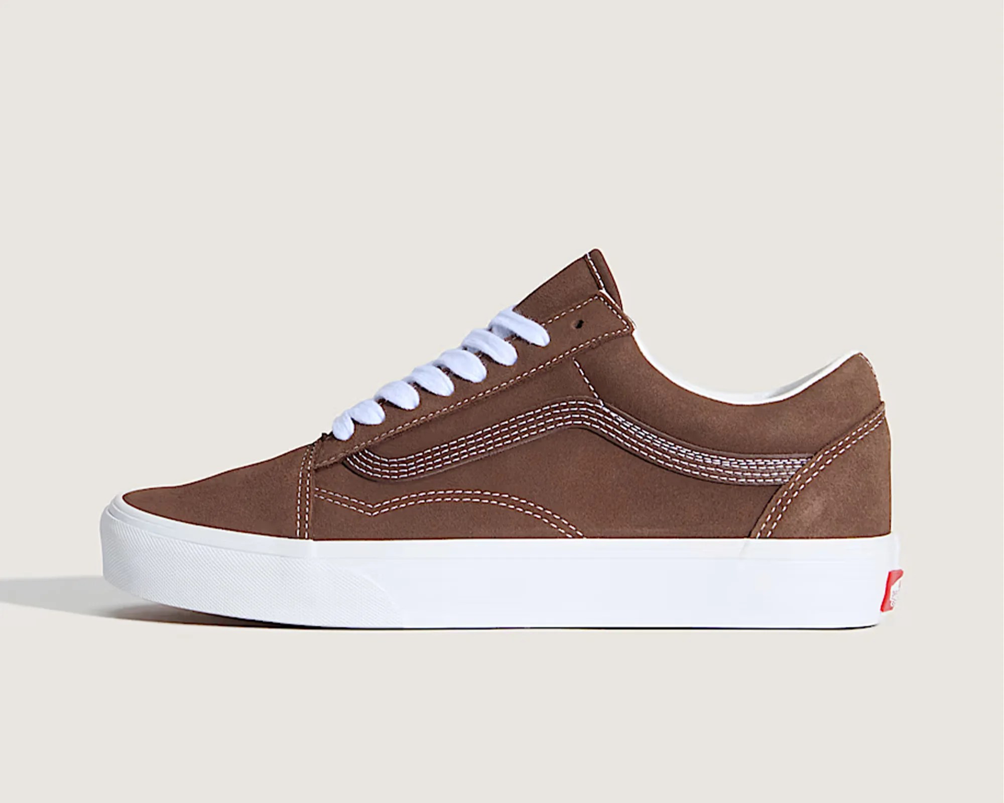 Brown suede Vans sneaker with white laces and thick white rubber sole.