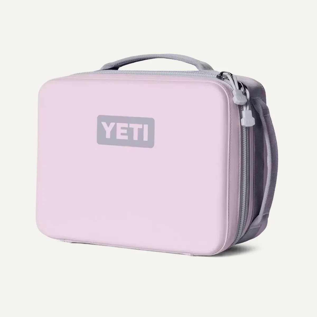Light pink rectangular YETI soft cooler bag with gray handle and zipper pulls.