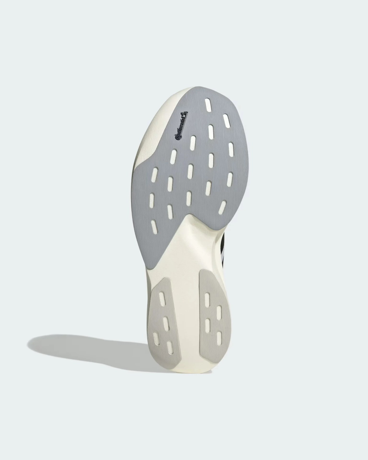 Sole of a white sneaker with gray rubber patches and Continental logo on a light background.