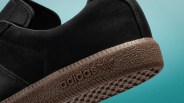 Close-up of black Adidas shoe with textured brown sole and Adidas logo on the side.