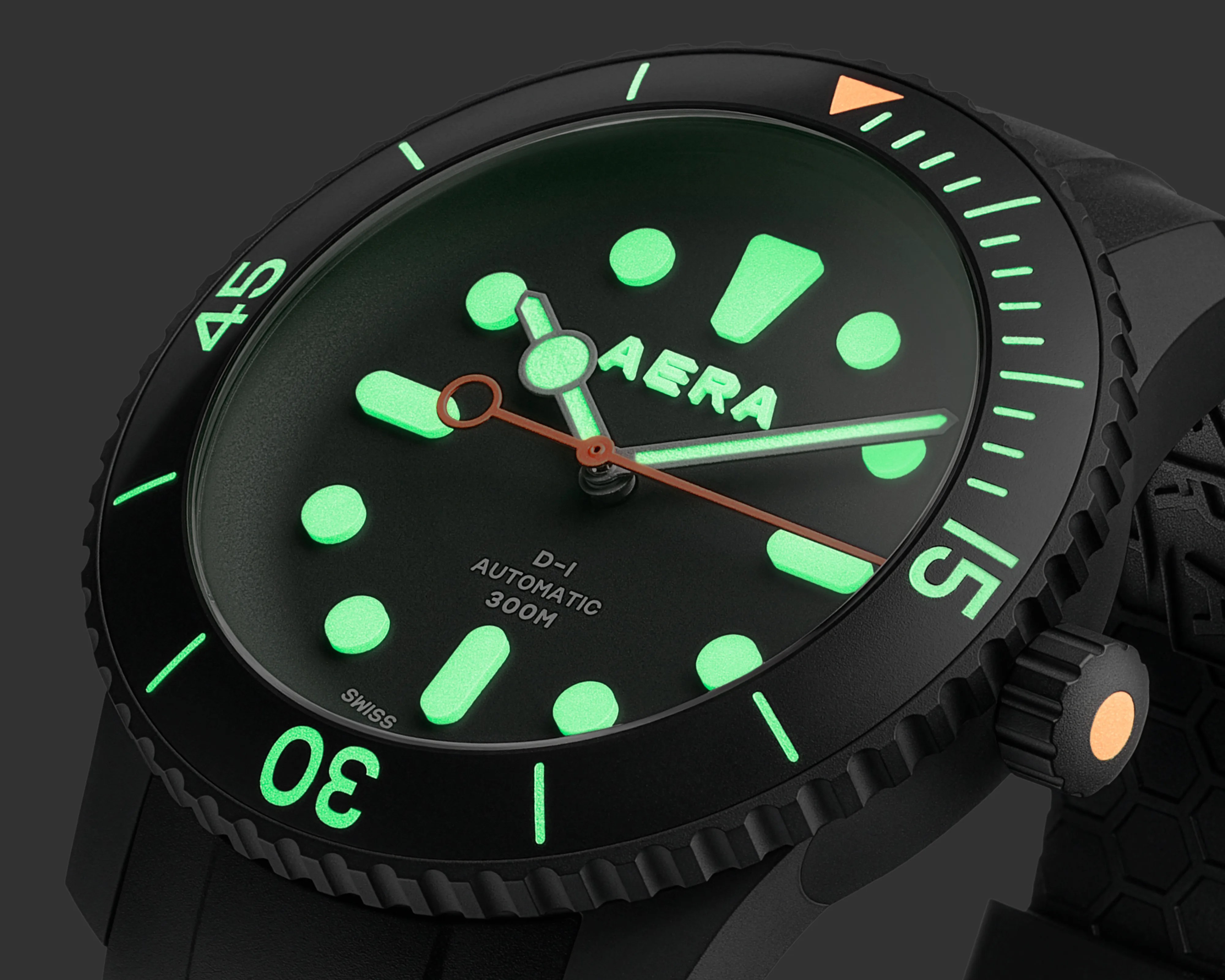 Black dive watch with glowing green markers and hands, orange second hand, and black rubber strap.
