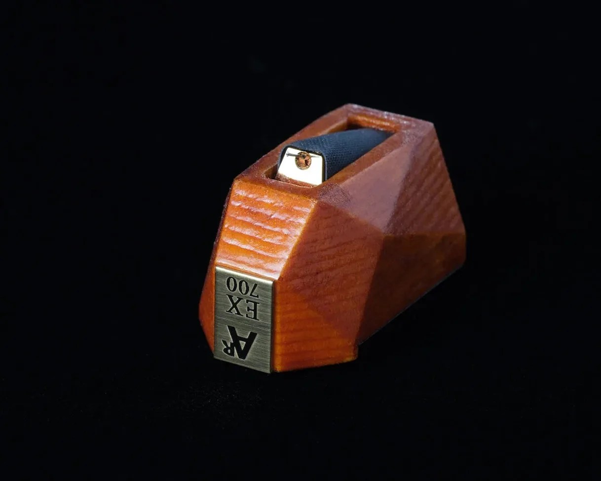 Wooden AR EX 700 stylus cartridge with a metal front plate on a black background.
