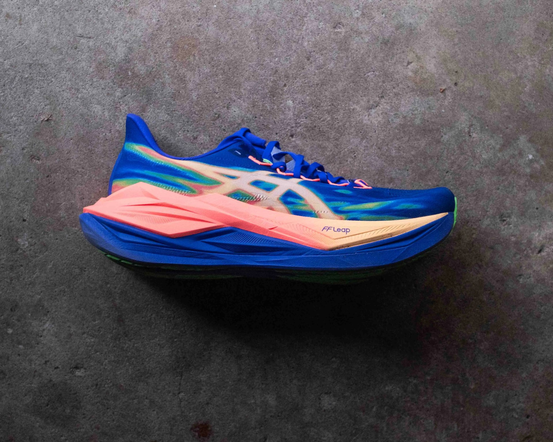 Blue and peach running shoe with "FF Leap" text on the side, placed on a gray concrete floor.