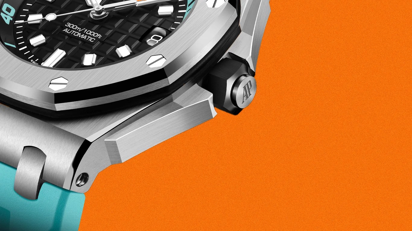 Close-up of a silver stainless steel watch case with black dial, hexagonal screws, and turquoise strap on an orange background.