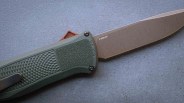 Folding knife with textured green handle and stonewashed blade marked "Z-WEAR" on a gray surface.