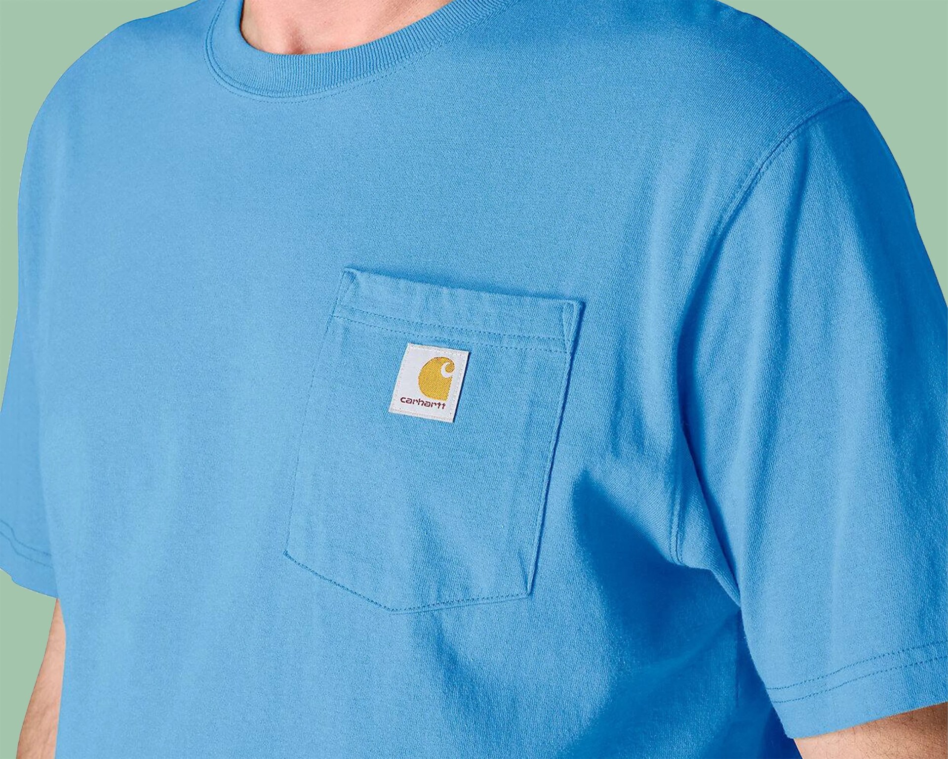 Light blue Carhartt T-shirt with a chest pocket featuring the brand's yellow logo patch.