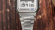 Digital silver metal wristwatch showing time 19:41:35 on a wooden surface.
