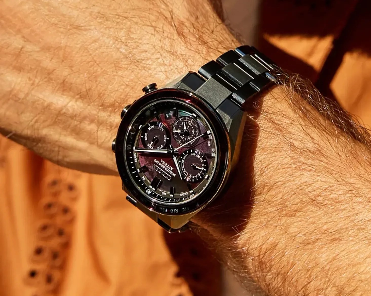 Black metal chronograph wristwatch with multiple dials and a textured dark face worn on a wrist.