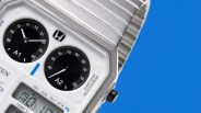 Close-up of a silver Citizen digital watch with dual black analog dials and a digital display on a blue background.