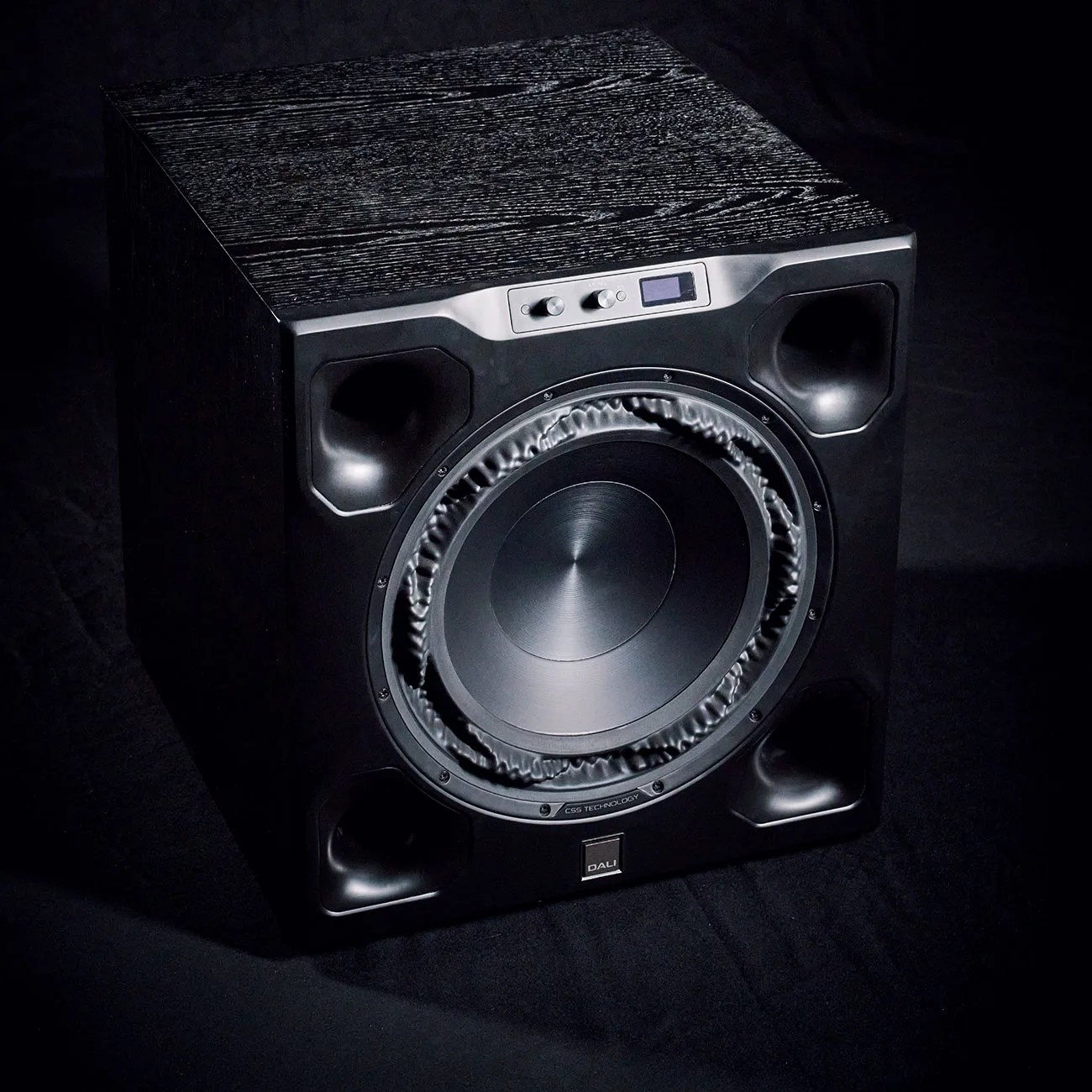 Black DALI subwoofer speaker with large central driver and control knobs on top front panel.