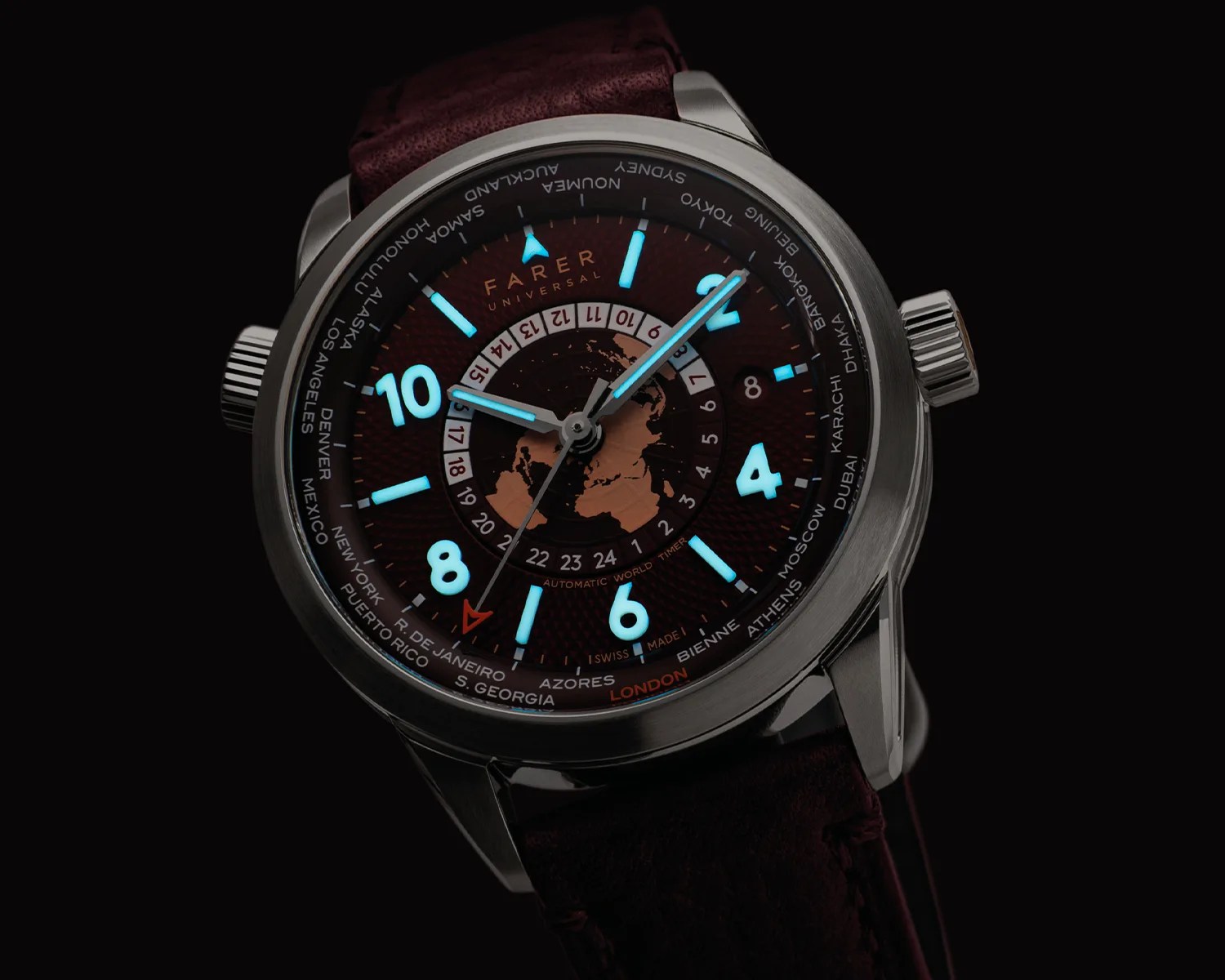 Round stainless steel Farer Universal wristwatch with luminescent blue numerals and hands, burgundy dial featuring a world map and city names, and a dark brown leather strap.