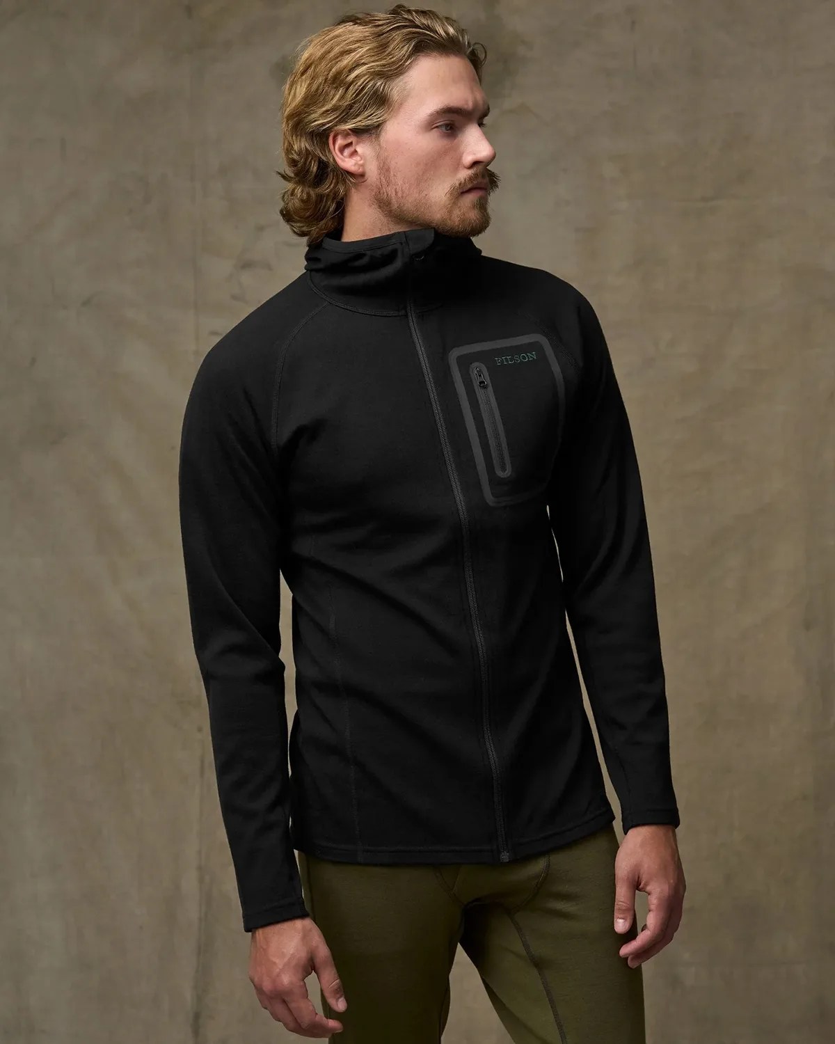 Black zip-up jacket with a zippered chest pocket worn by a person against a plain background.