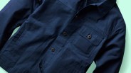 Navy blue button-up jacket with a chest pocket and side pockets on a light background.