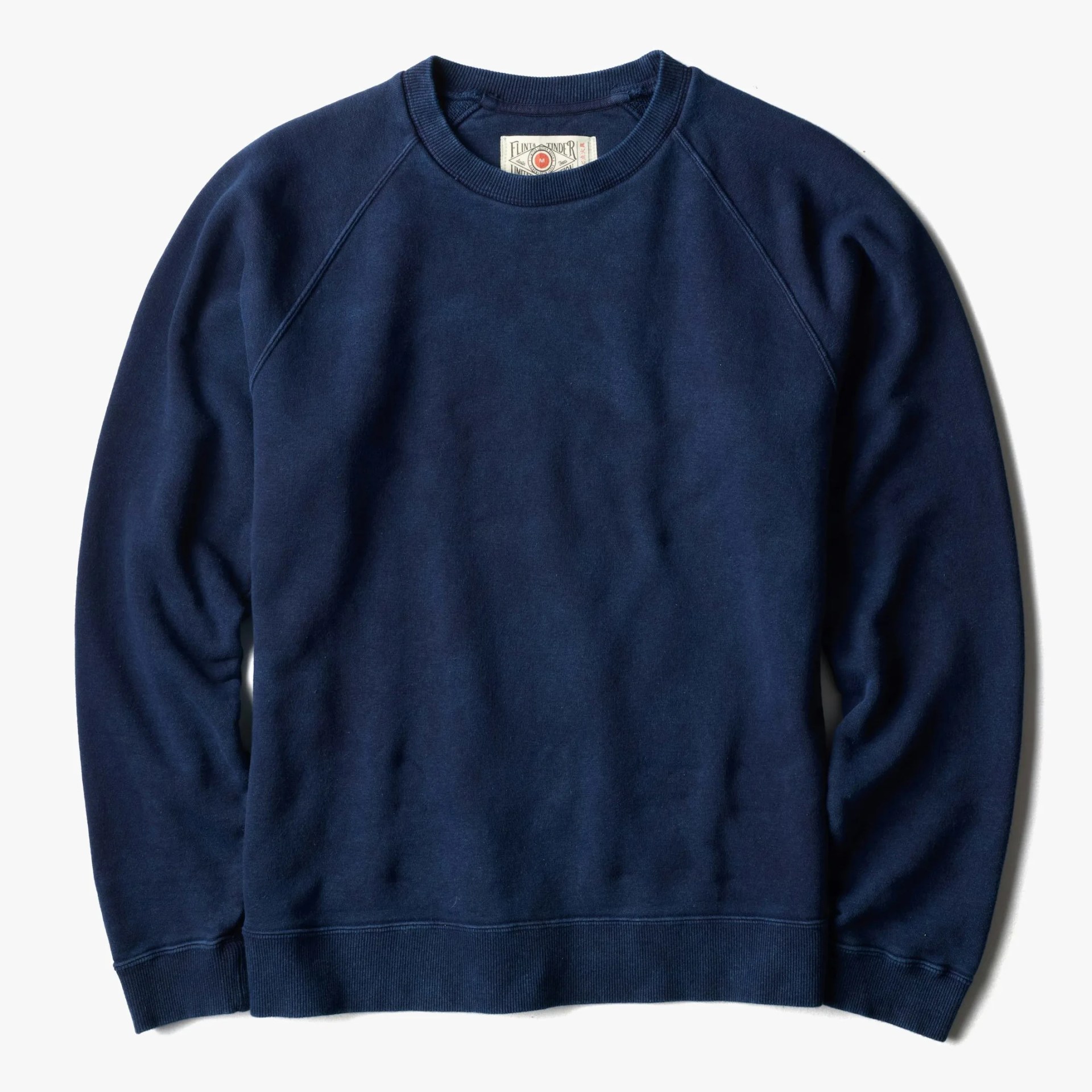 Navy blue crewneck sweatshirt with ribbed cuffs and hem laid flat on a white background.