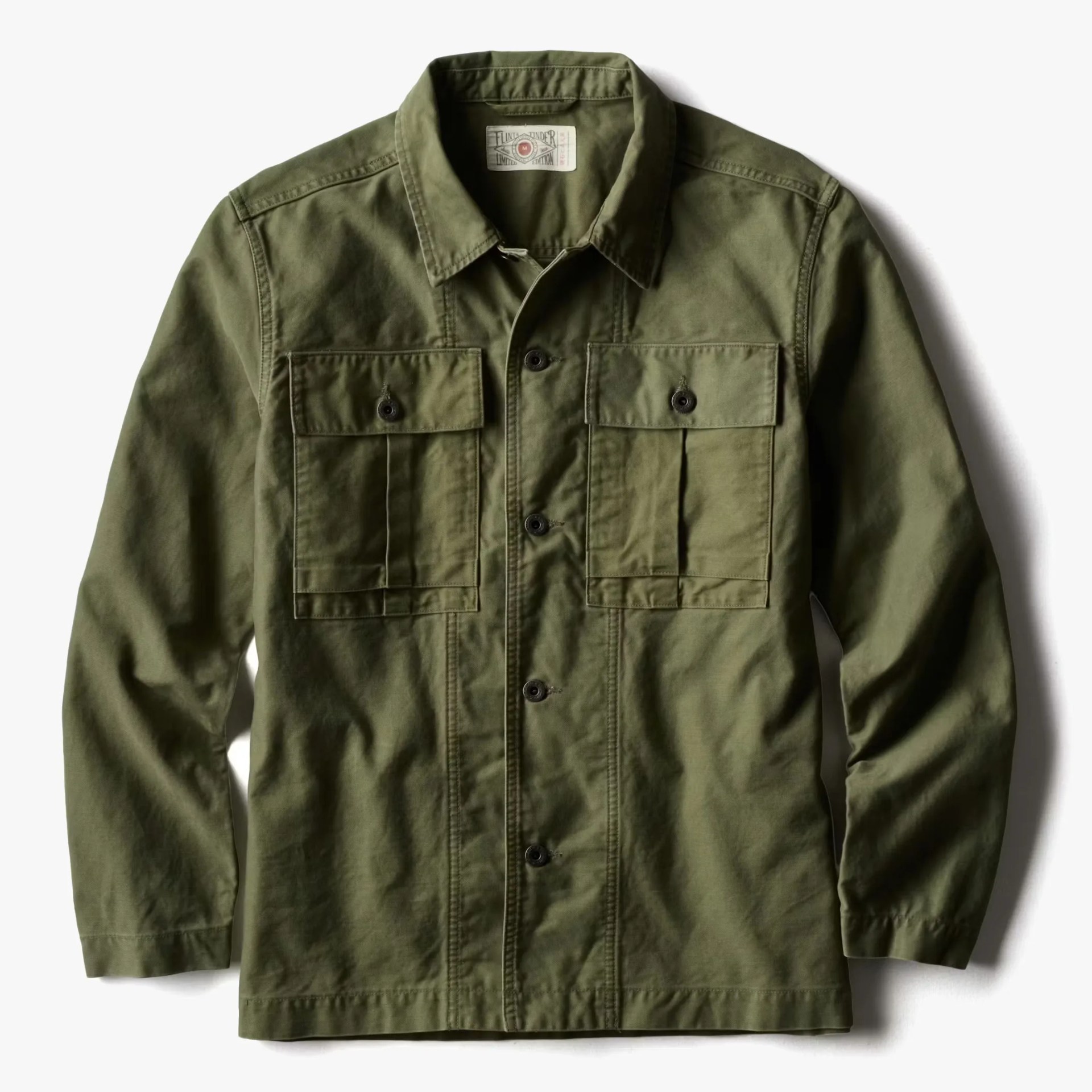 Olive green button-up jacket with two front flap pockets and long sleeves.