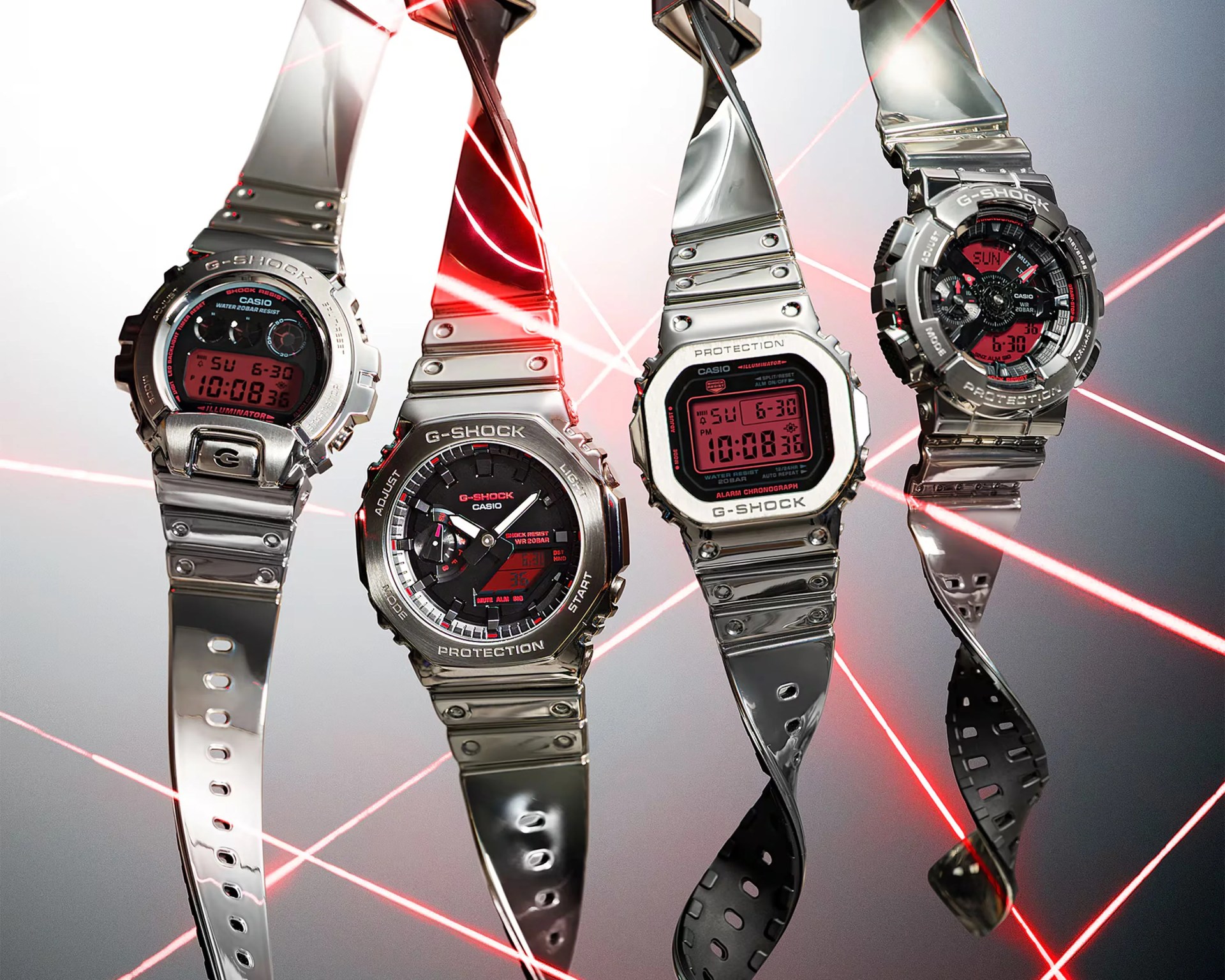 Four silver Casio G-Shock watches with red digital and analog displays, suspended against a background of red laser beams.