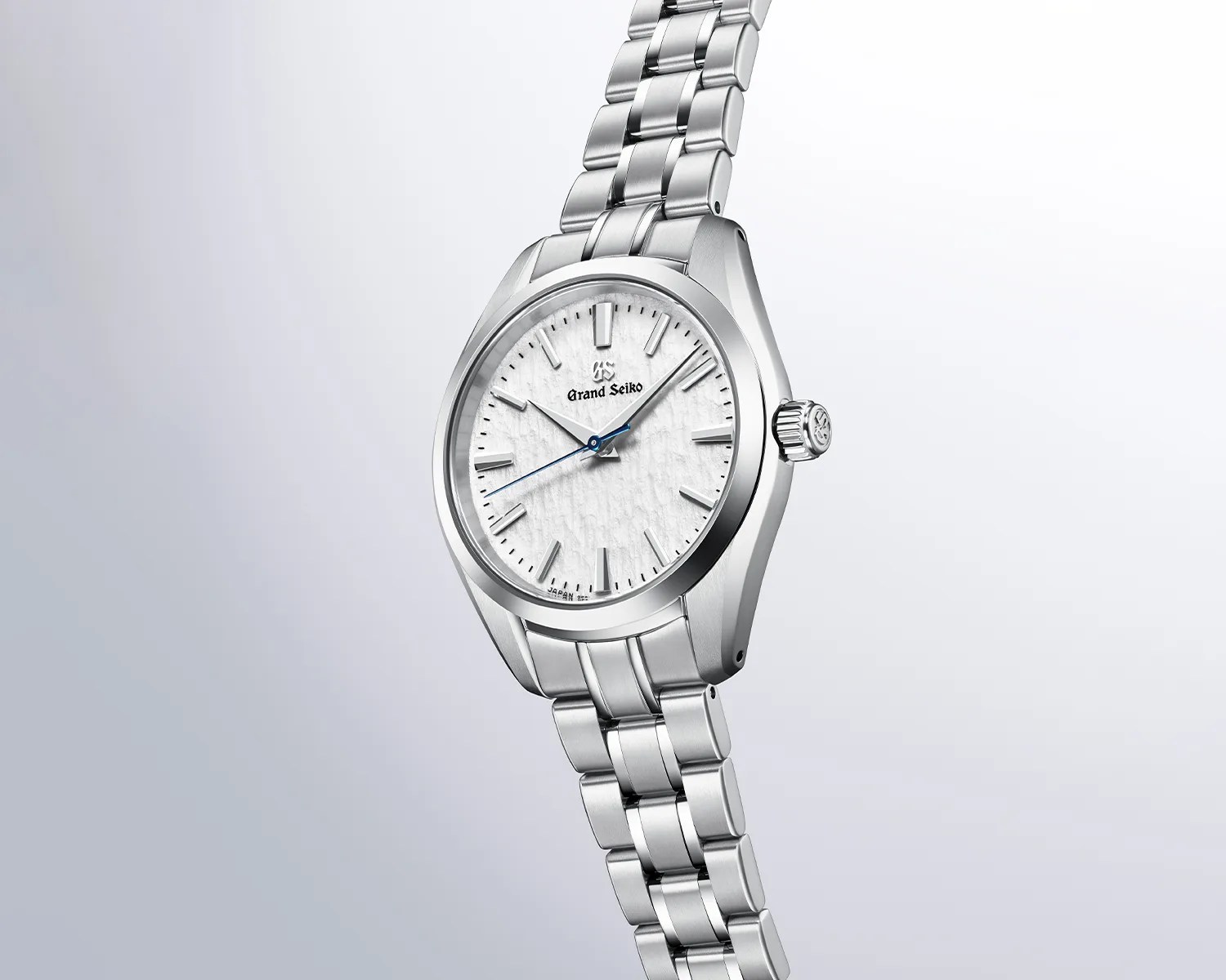 Silver Grand Seiko wristwatch with textured white dial and stainless steel bracelet.