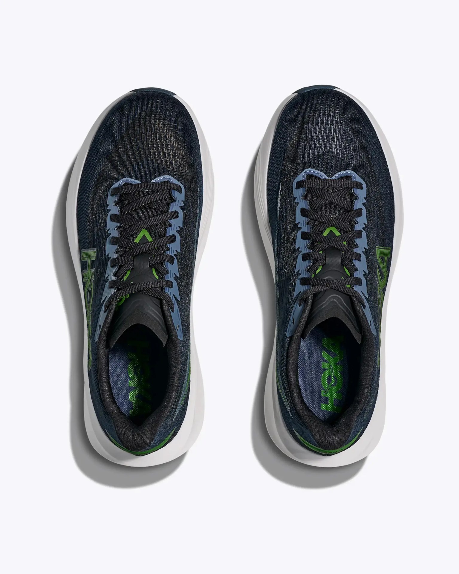 Pair of black and blue running shoes with green accents and white soles viewed from above.