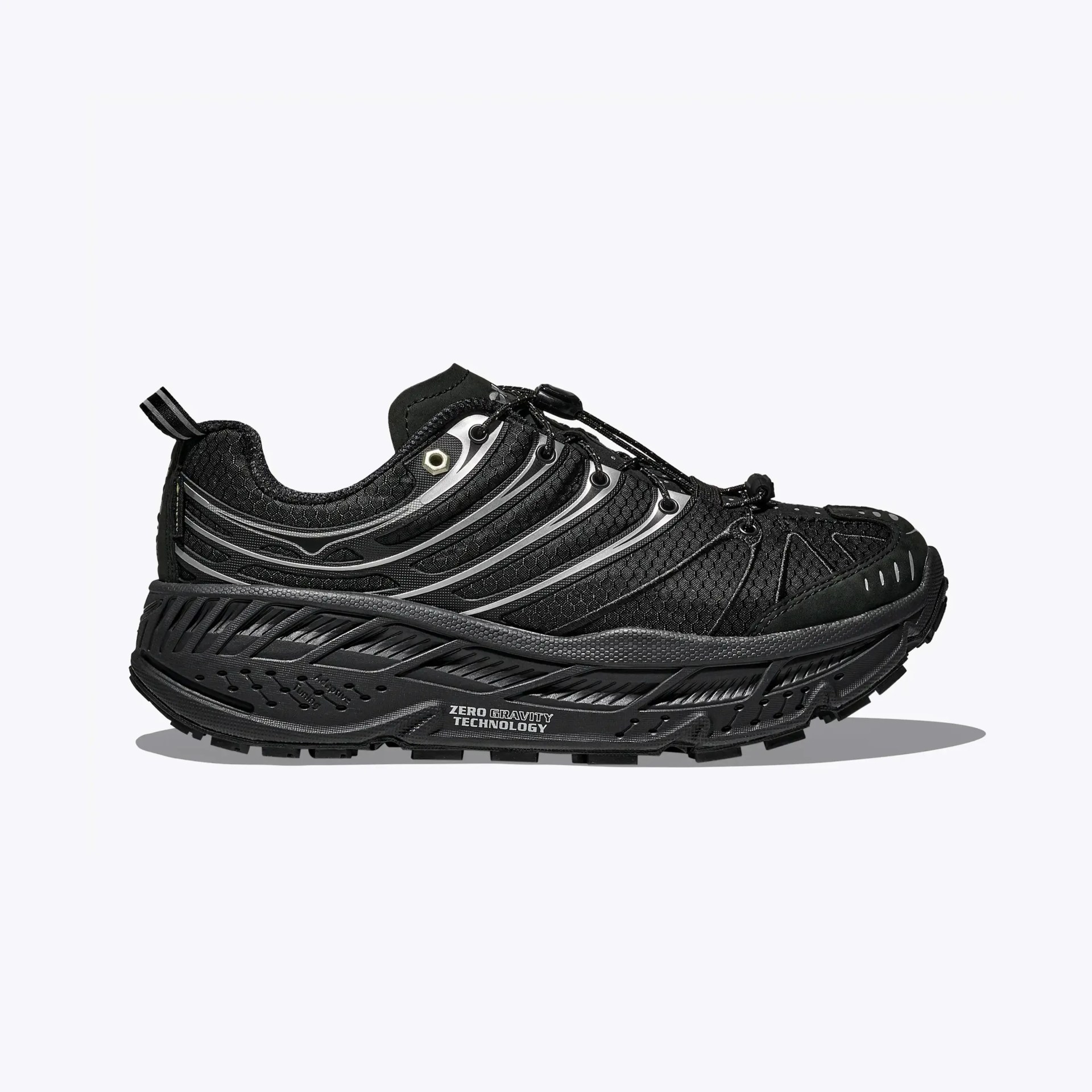 Black athletic shoe with textured upper, reflective silver accents, and thick sole labeled "Zero Gravity Technology.
