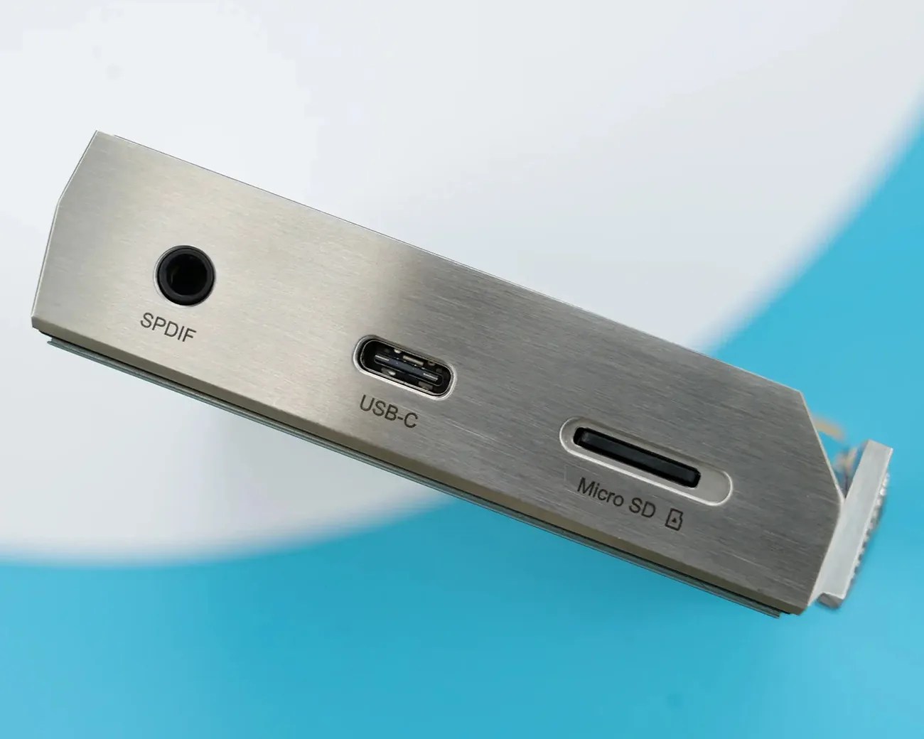 Metal panel with SPDIF, USB-C, and Micro SD card slots on a tech device.