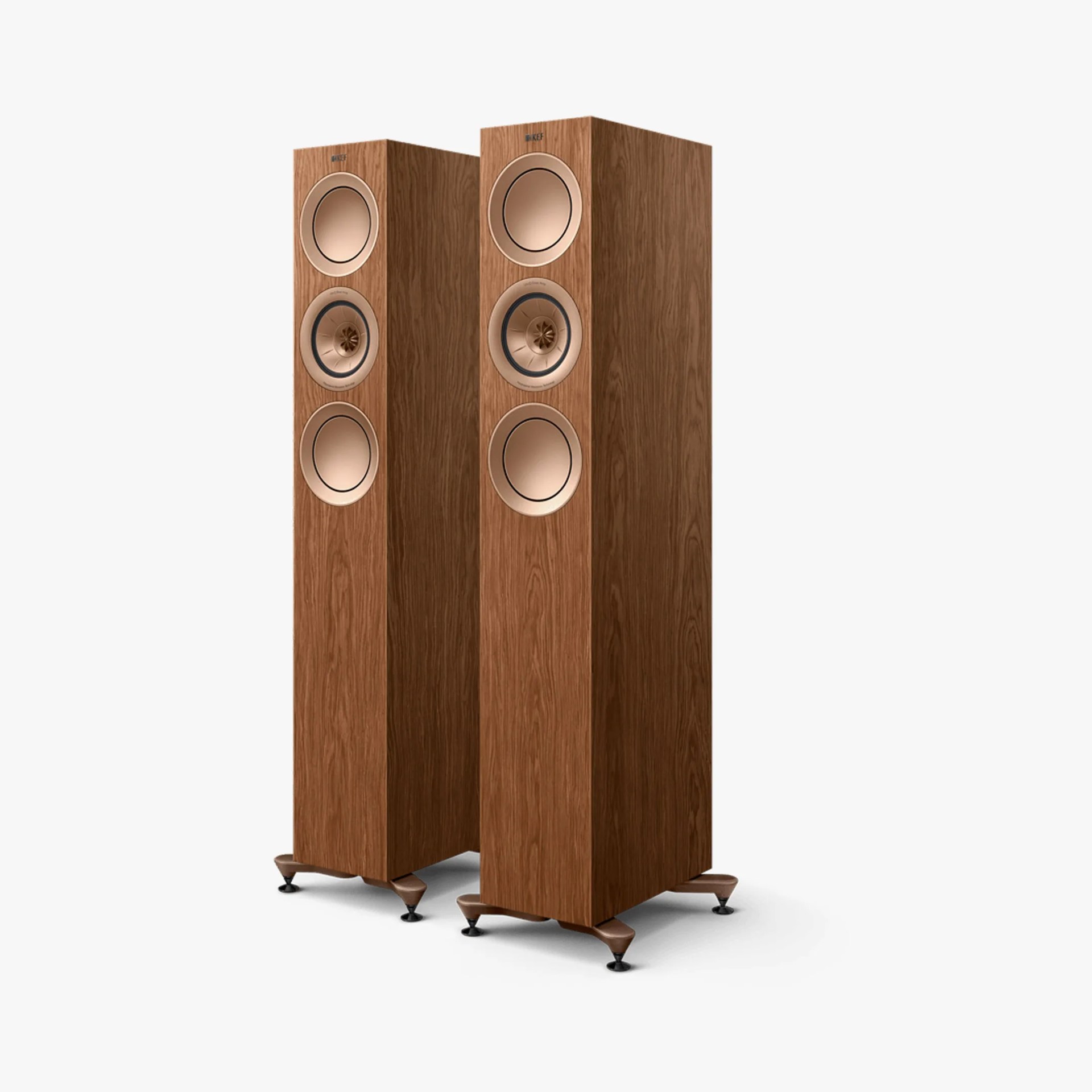 Pair of tall floor-standing speakers with wood veneer finish and copper-colored drivers on angled feet.