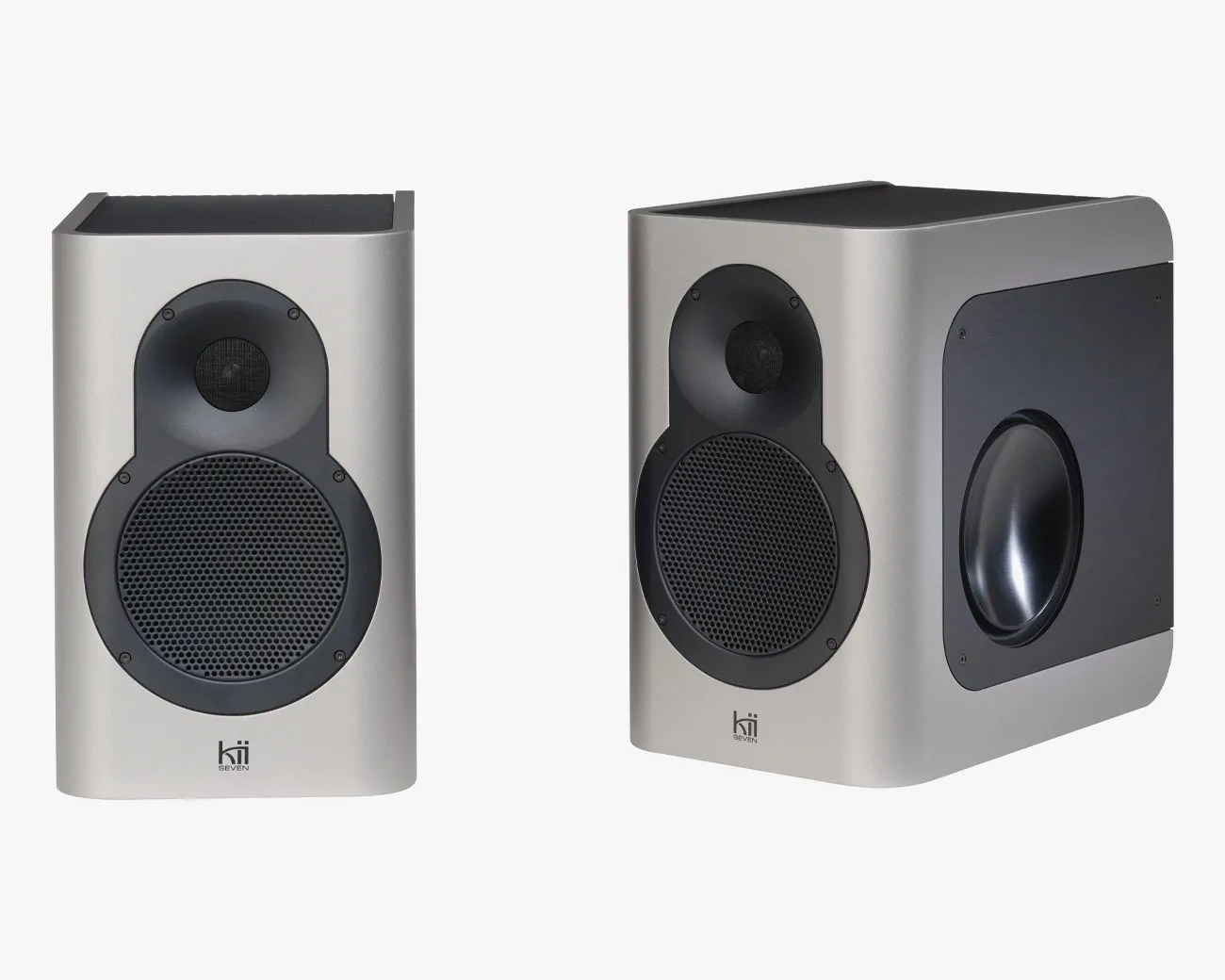 Pair of silver Kii Seven speakers with black speaker grilles and side bass ports.