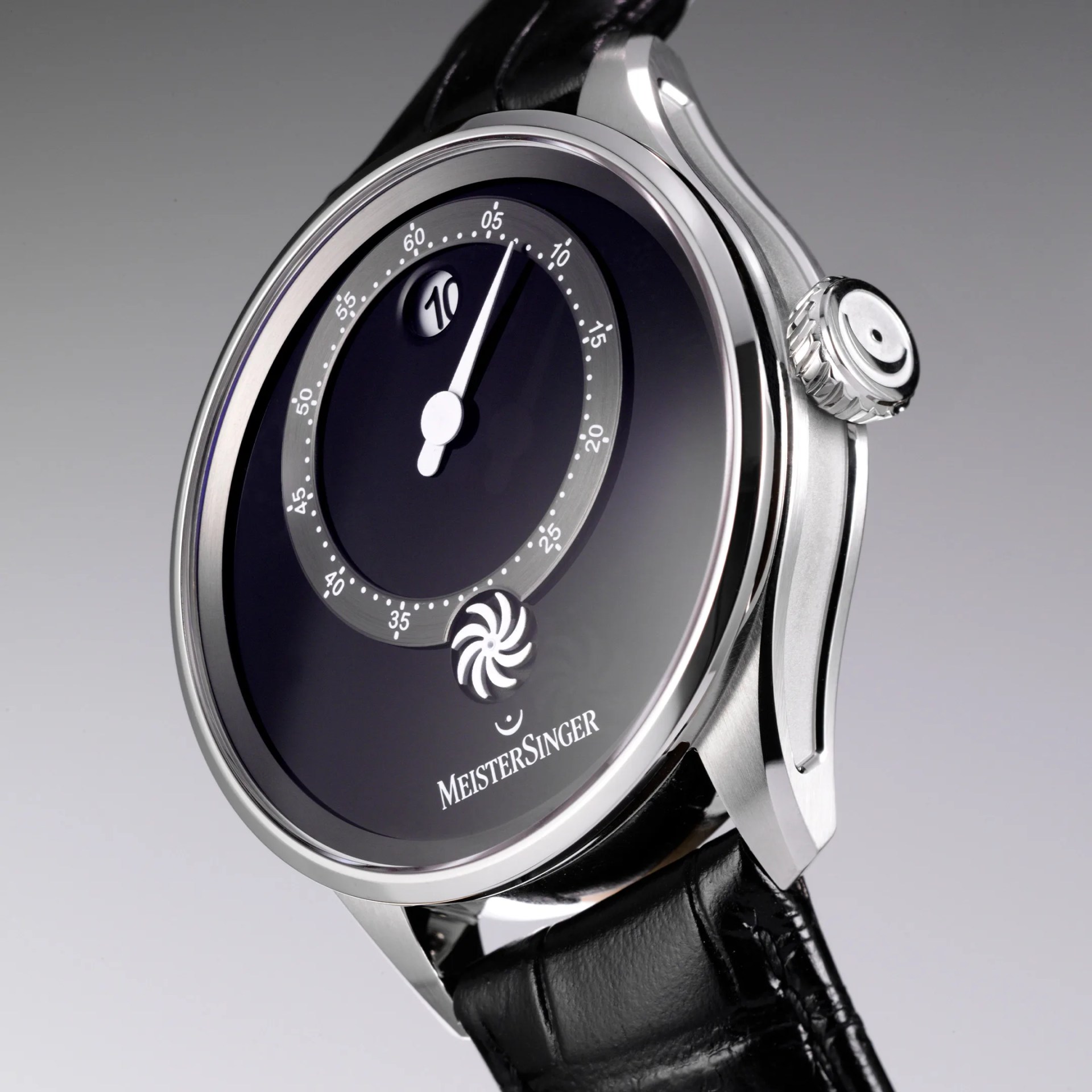 Silver MeisterSinger wristwatch with black dial, single white hand, date window, and black leather strap.