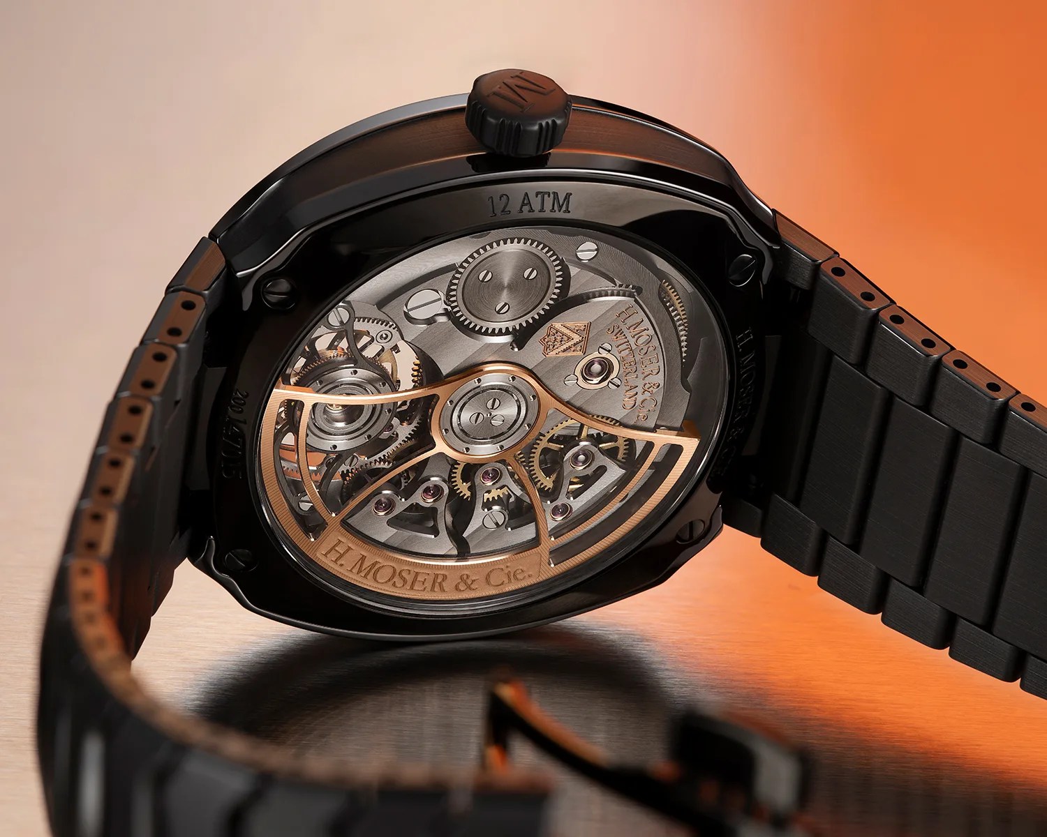Close-up of the back of a black ceramic wristwatch showing intricate mechanical gears and "H. MOSER & Cie." engraving.
