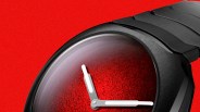 Black metal wristwatch with a textured red dial and white hour and minute hands.