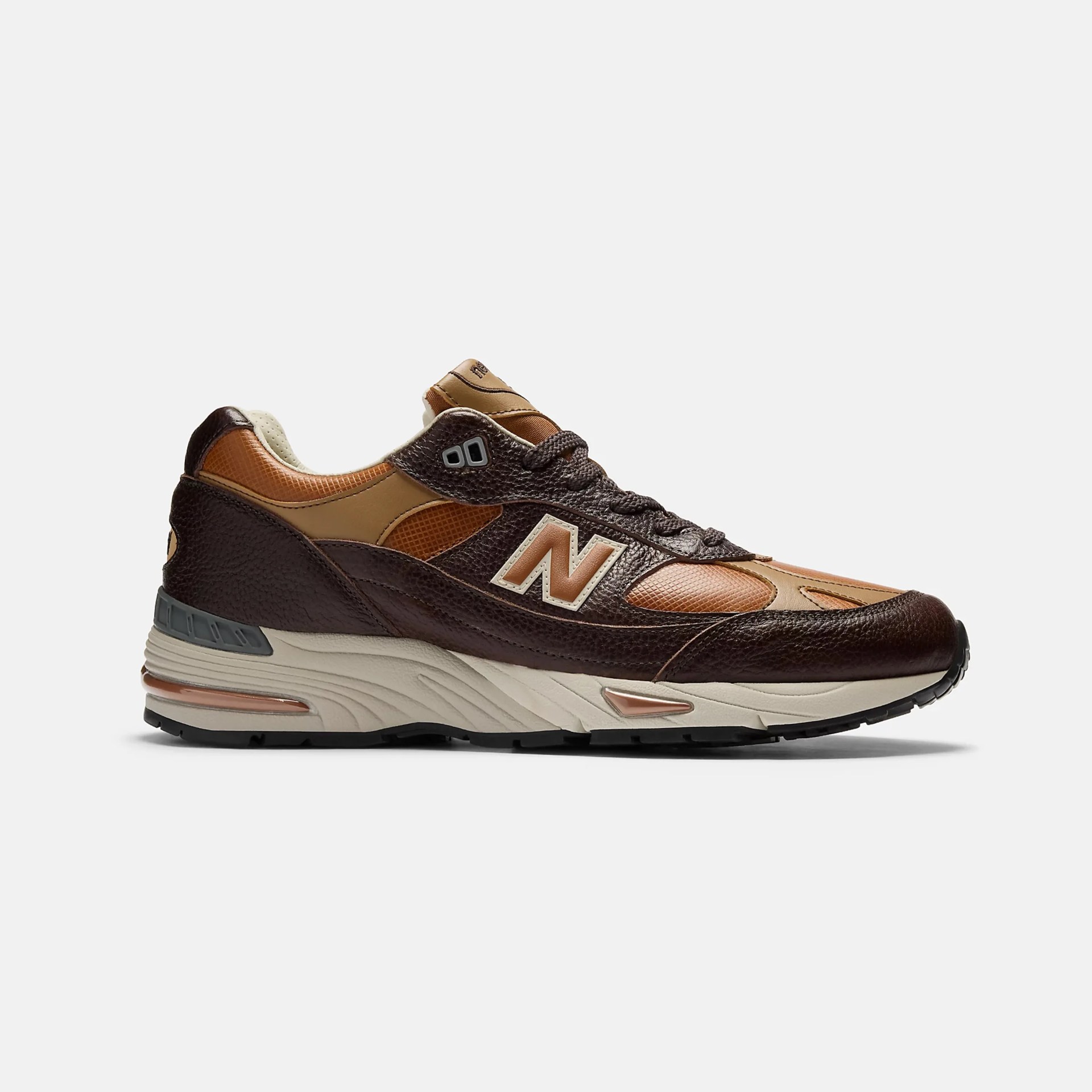 Brown and tan New Balance sneaker with textured leather and beige sole.