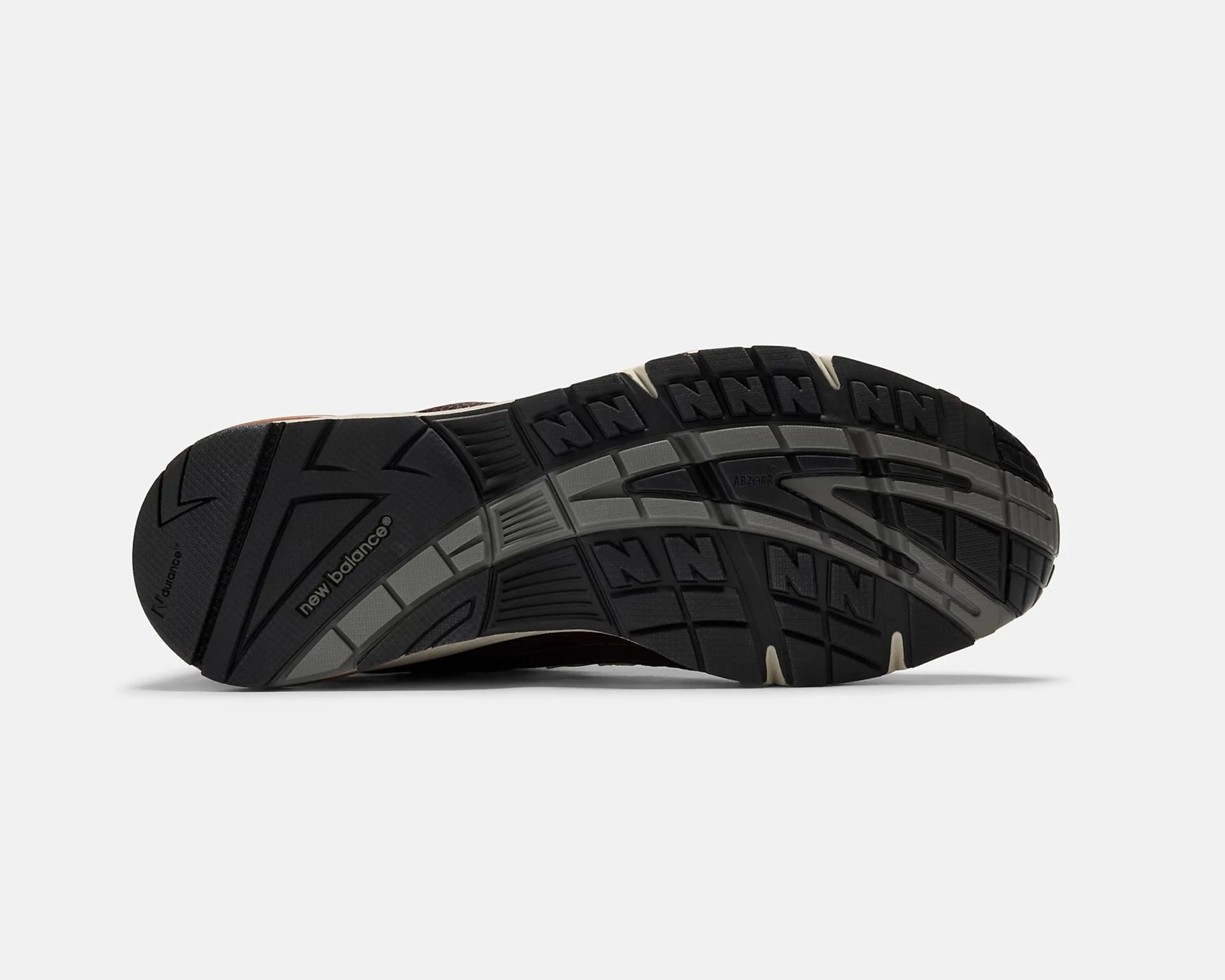 Black and gray New Balance shoe sole with textured tread and "new balance" logo.